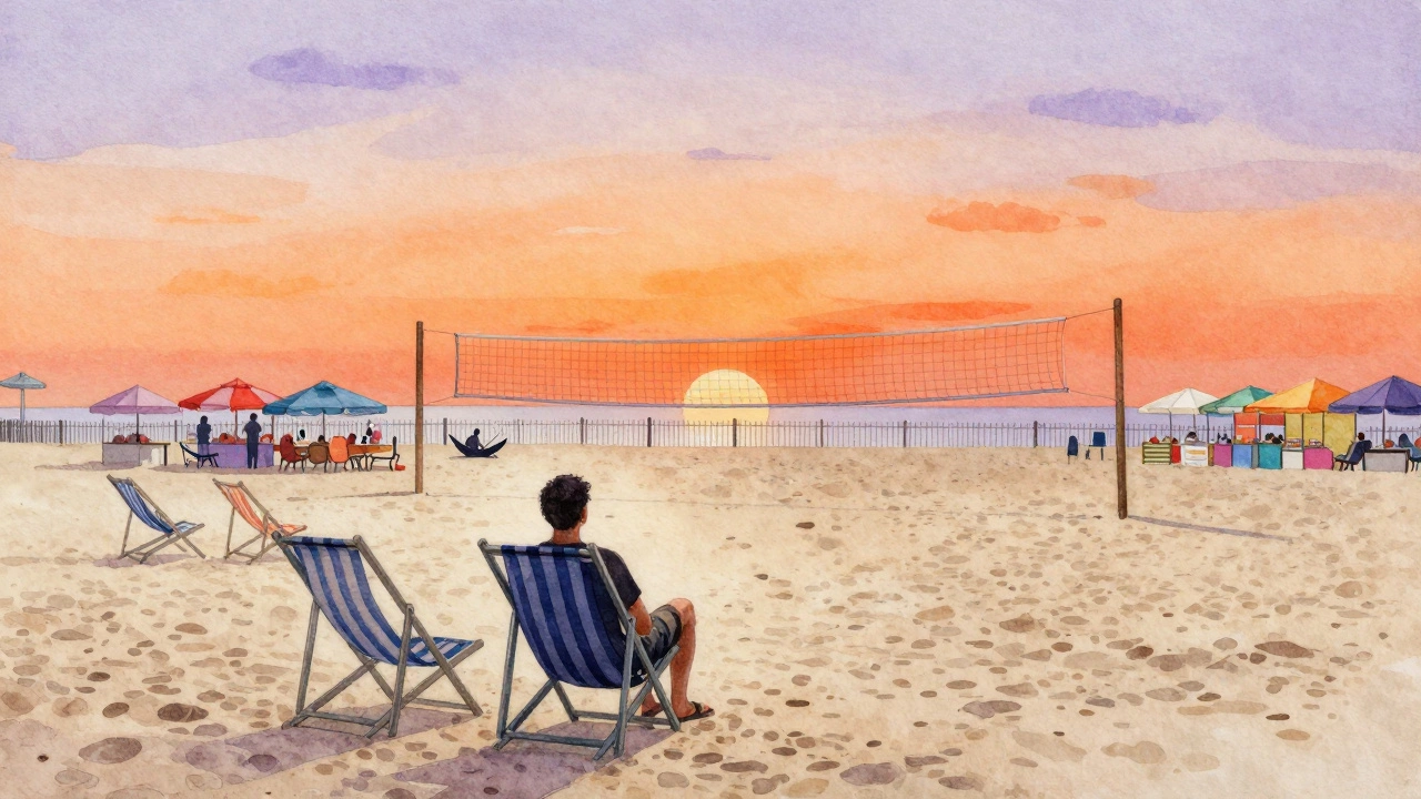 An empty beach resort at sunset with faint outlines of authentic local life beyond a fence.